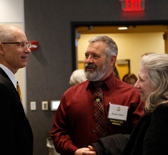 Mike Lamb, Vice President of Wichita State University Foundation visits with Randy and Lynette Miller at the Society of 1895 luncheon