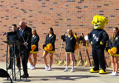 Brent Kemnitz, WSU assistant athletic director and a former pitching coach for WSU baseball, gave remarks as members of the WSU Spirit Squad listened.