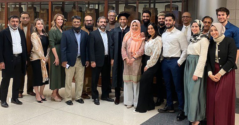 Khalid Raza, center in commencement attire, accepted an honorary doctorate during winter graduation ceremonies at Wichita State. About 20 family members and friends attended the event in support.