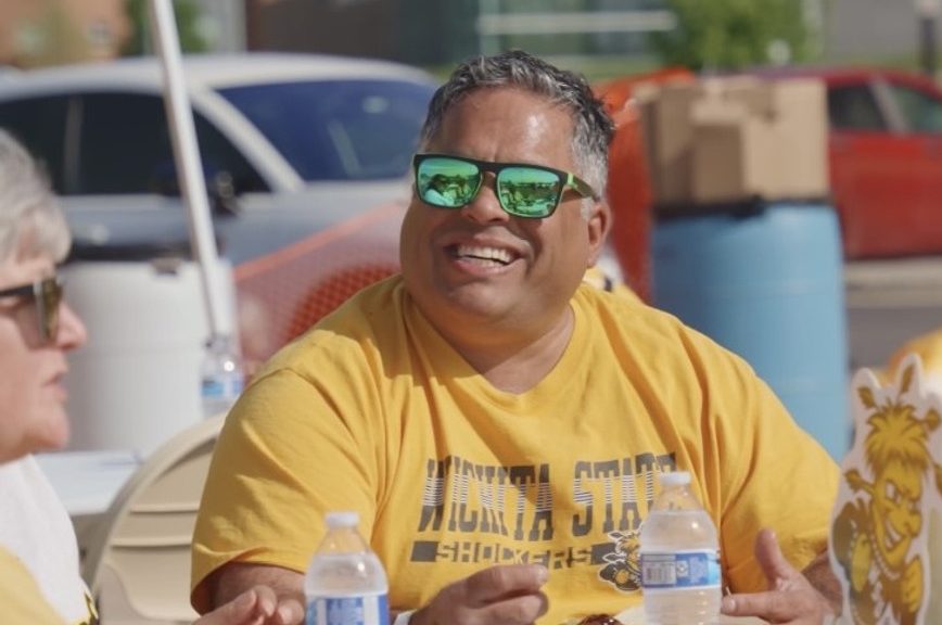 Man in shocker gear smiling at a tailgate party