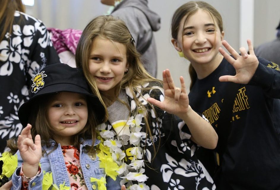 3 young girls posing together holding up the shocker sign