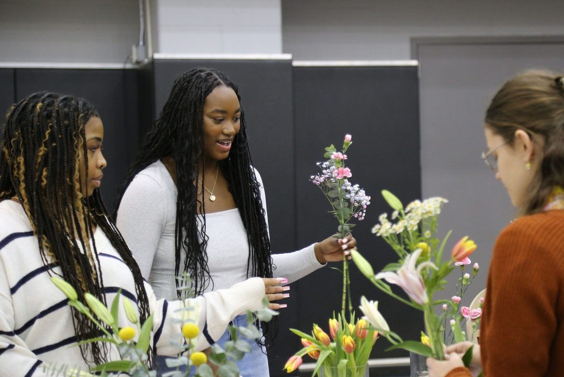 Two women building a bouquet of flowers together