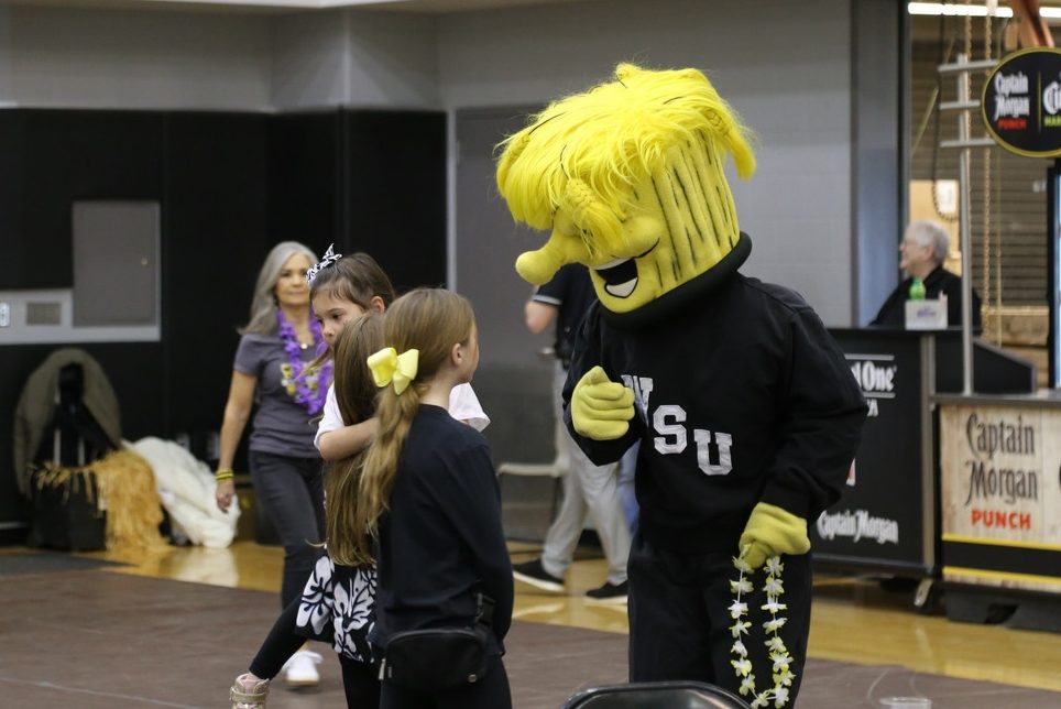 WuShock, WSU's mascot interacting with two young girls