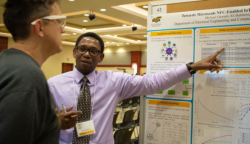 Wichita State University graduate student shares his research with a fellow student