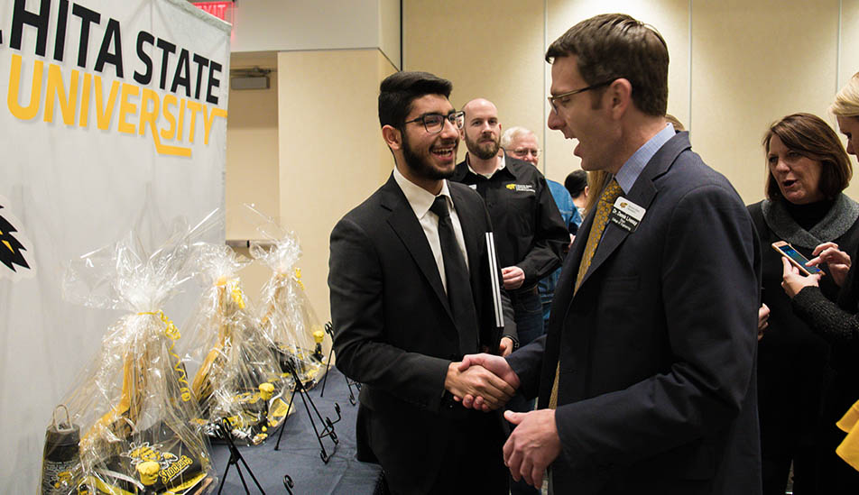 Gehad Qaki,Wichita State Gore Scholar receiving congratulations from Dean Livesay.