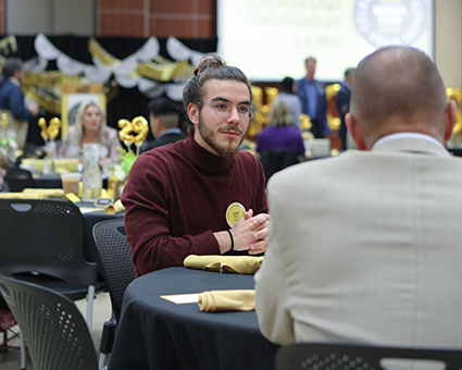 Josef Menga chats with other attendees at his table.