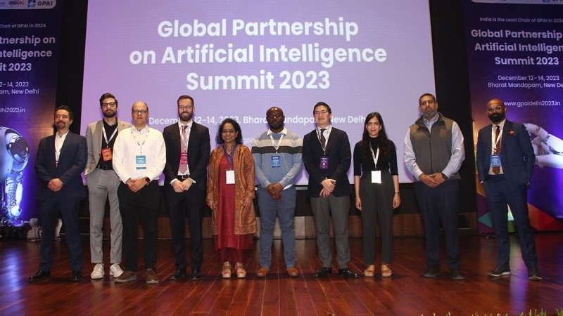Howard Lakougna, center, poses at the GPAI summit in Delhi.